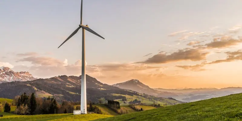 Gro&szlig;e Windkraftanlage in bergiger Landschaft bei Sonnenuntergang als Beispiel f&uuml;r Projektlogistik Erneuerbare Energien.